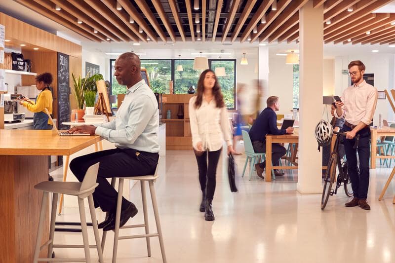 Interior Of Busy Office Coffee Shop With Businesspeople Working At Tables